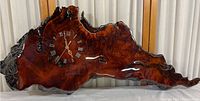 Front view of the live edge redwood burlwood clock mounted horizontally, showing polished wood grain and clock face.