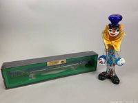 Photo of Elie Denoix Cognac XO glass dog bottle boxed and Murano clown figurine shown together
