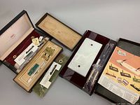 Photo showing three CROSS desk sets in original boxes with pens and stone bases visible