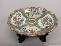 Bowl on stand showing scalloped rim and painted interior.