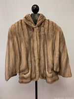 Front view of a vintage ladies mink fur jacket displayed on a mannequin, showing the full jacket length and wide shoulders.