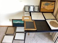 Photo showing assortment of blank frames with 2 landscape paintings and various mat openings.