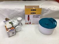 Photo showing red Bella handheld blender, progressive chopper, spiralizer, salad spinner, and packaging box.