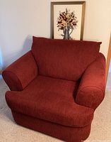 Front view of the solid red oversized chair showing the plush cushioning and fabric texture.