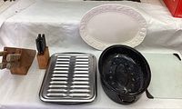 Photo of all items including roasting pans, ceramic platter, cutting board, and the two wooden blocks with knives.