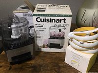 Cuisinart Mini-Prep Processor with brushed metal base alongside stacked white plastic egg rings, box for processor visible in background