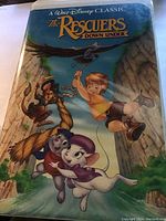 Front cover of The Rescuers Down Under Disney VHS showing main characters and title.