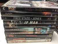 Stack of 10 DVD movies showing titles including Always Fairy Villains, Purple Rain, Free State of Jones, Ip Man 3, New Moon, Licence to Kill, GoldenEye, The Hurricane, Halloween and 3000 Miles to Graceland.