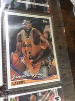 Close-up of James Worthy Lakers basketball card with player dribbling and basketball in hand.