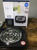 Photo of Mainstays single burner electric stove along with its box