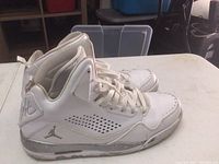 Side view of white Nike Flight sneaker showing perforated side panels, Jumpman logo, and wear.