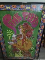 Photo of the full framed Pink Floyd poster showing the colorful psychedelic design with floral borders