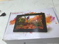 Photo of Chromosome Tablet PC packaging box showing nature scene on screen and colorful splashes.