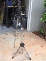 Full view of metal tripod stand and telescope base mounted on top, showing adjustable legs and knobs