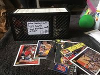 Black plastic crate filled with thick stack of basketball cards with a label showing quantity and featured players.
