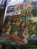 Xbox 360 Kinect Adventures! game case featuring animated surfing characters, unopened.