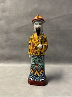 Front view of the 14-inch porcelain emperor figurine showing detailed hand-painted traditional yellow robe and facial features.