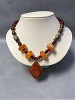 Front view of entire necklace displayed on bust showing beads and pendant