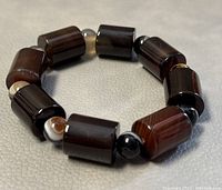 Top view of the beaded onyx stretchy bracelet showing dark cylindrical beads and smaller round accent beads.