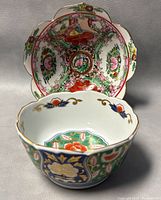Front view of the two lotus-shaped porcelain bowls showing their colorful designs and shape.