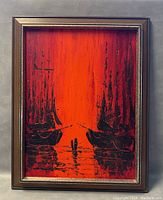 Front view of framed oil painting showing two ships silhouetted against a vibrant orange-red sunset background.