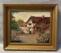 Framed oil painting depicting a countryside homestead with two figures and a flower garden, signed and framed in a gold ornate frame showing minor wear.