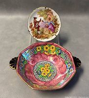 Limoges porcelain plate with painted pastel scene, man with guitar and woman, scalloped edges with gold trim, and Maling porcelain bowl with colorful floral interior and black handles.