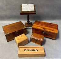 Photo of all items in lot including two medium wooden boxes, small carved box, domino box, and miniature book stand with open book