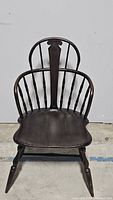 Front view of the antique Windsor chair showing the spindle back and central carved splat.