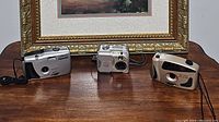 Overview of three cameras including Lazerfocus Panorama, Polaroid, and DS Max HC 2000