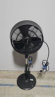 Full view of the Frigidaire black pedestal fan with power cord and base