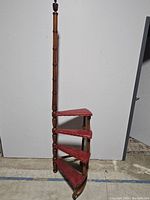 Full view of four-step library ladder showing wood frame and red upholstered steps