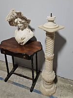 Full view of marble bust on tabletop beside matching pedestal