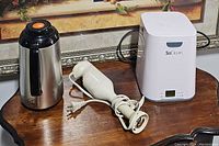 Thermal carafe, immersion blender, and SoClean device on wooden surface.