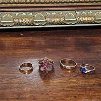 Group shot of four rings on wooden surface