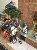 Painted wood lamp post with Christmas decorations including pinecones, greenery, red bird topper, snowman flag, and wood bird houses arranged at base