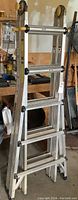 Full view of aluminum extension ladder showing side rails, rungs and plastic handles.