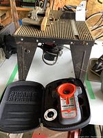 Router table with two Craftsman routers mounted underneath, black metal with a textured surface.