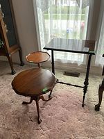 Three wooden side tables together near a window with lace curtains, showing their relative sizes and shapes.