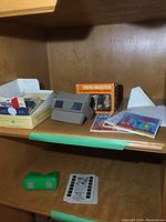 Vintage GAF View-Master viewer with original orange box, boxes and assorted reels and Tru-Vue slides on wooden shelf