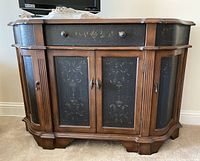 Front view of wood accent chest showing carved patterns on drawer and doors, with double doors and side doors closed.