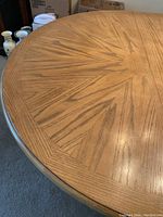 Close-up of the wooden tabletop surface showing starburst sunburst wood grain pattern.