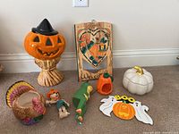 Full lot of Halloween and Thanksgiving decorations including pumpkin jar, turkey dish, scarecrow, dinosaur figure, wooden welcome plaque, and Halloween trivet.