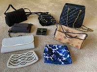 Photo of 9 assorted pocketbooks and wallets arranged on carpeted floor showing different styles and colors