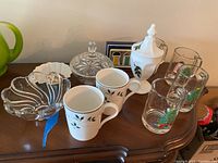 Photo showing the variety of Christmas mugs, candy dishes, and decorative bowls arranged on a wood surface