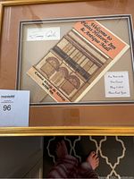 Framed hand fan framed with signature and small plaque inside a gold frame.