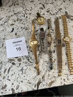 Six assorted ladies' wristwatches arranged on a light marble surface with a MaxSold lot card.