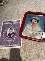Photo showing special edition Illustrated London News commemorating King George VI's death alongside a metal tray with Queen Elizabeth II portrait.