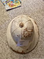 Top down view of the safari helmet showing heavy chipping and rust over white paint.