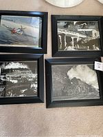 Four framed calendar prints on carpet with trains and planes theme